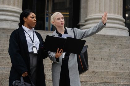 Mulheres com crachás conversam em um escritório público sobre um projeto para a cidade.