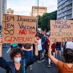 Manifestantes seguram cartazes em uma manifestação por direitos humanos e democracia em São Paulo.