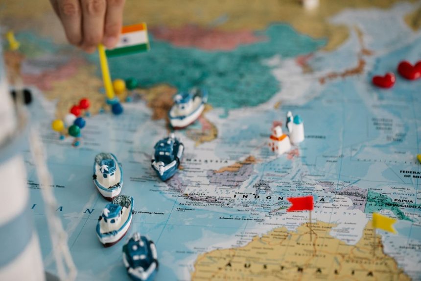 Mapa-múndi com pequenos navios e bandeiras indicando diferentes localidades e rotas do comércio internacional.